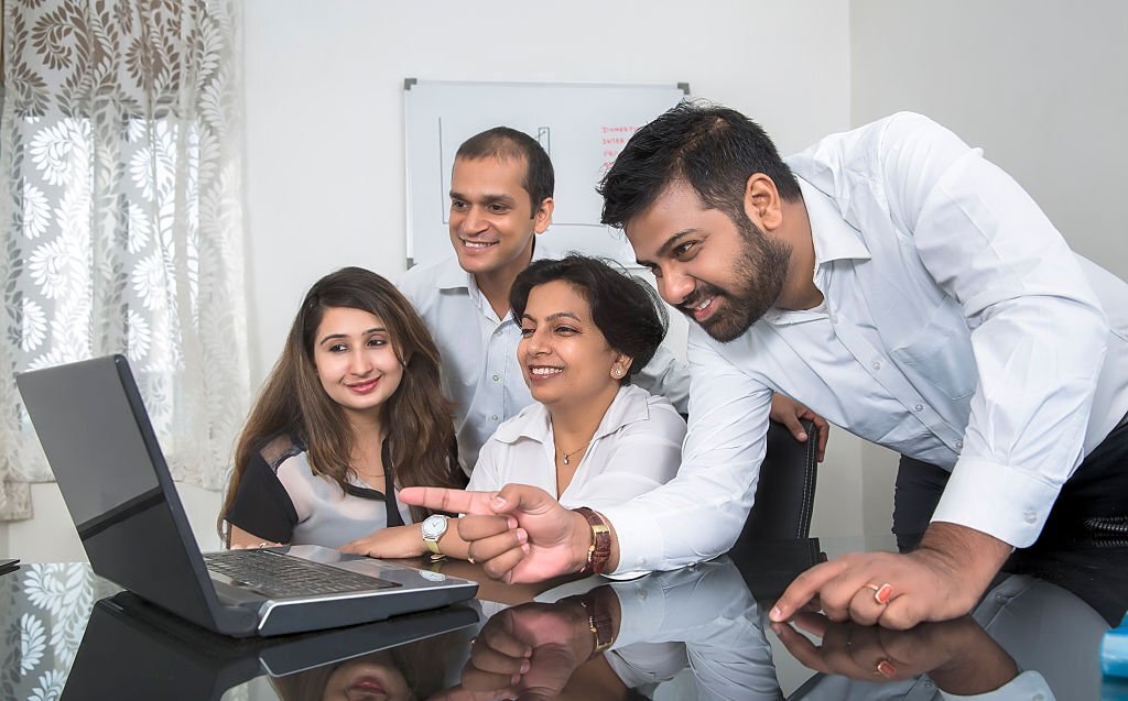 A Small Group Of Four People Gather Around For A Group Discussion