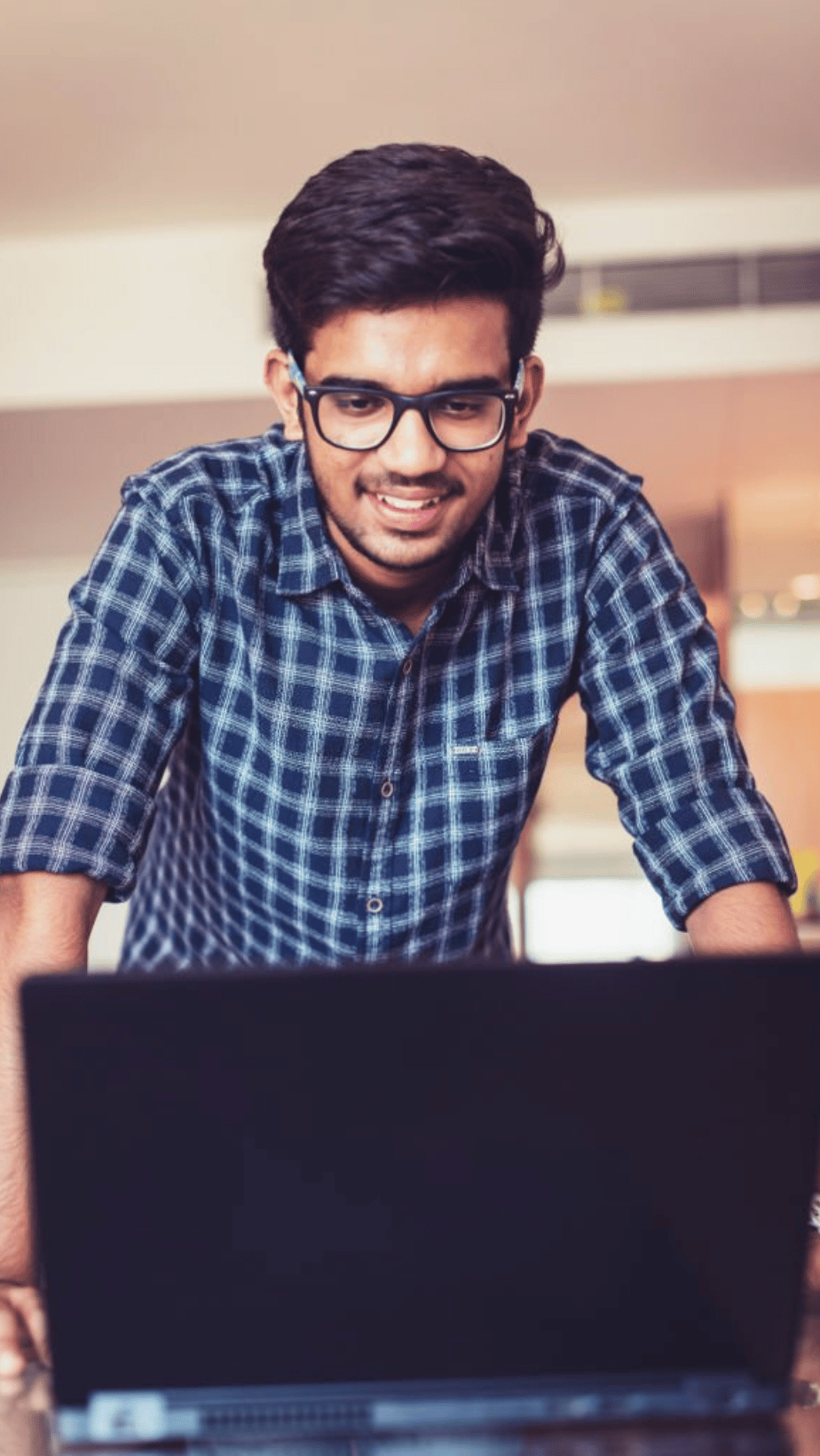 A Man Standing In Front Of Laptop